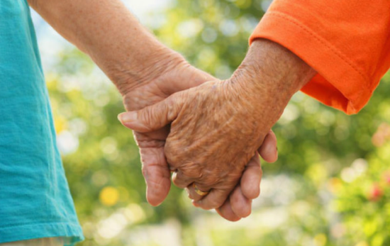 oud koppel die handen vast houden